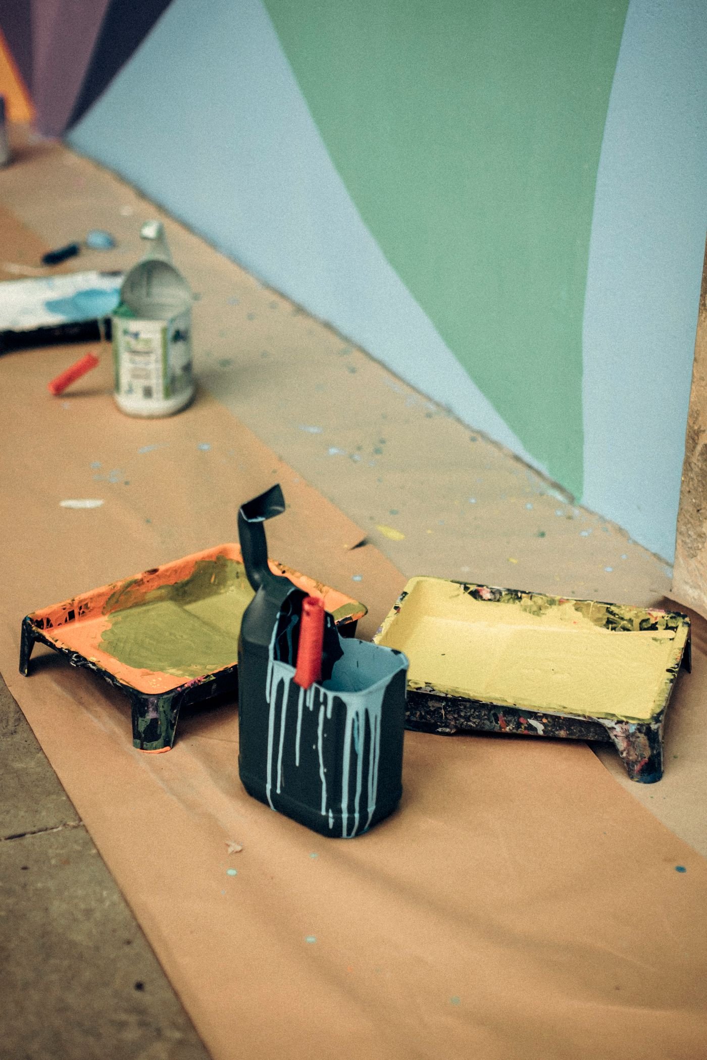 Painted blue and green wall with paint supplies