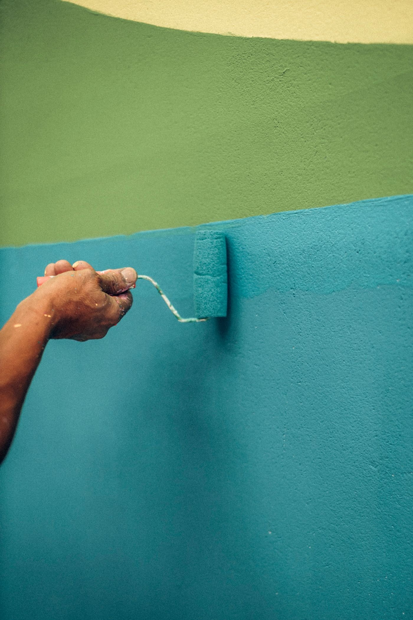 Brush painting a teal wall